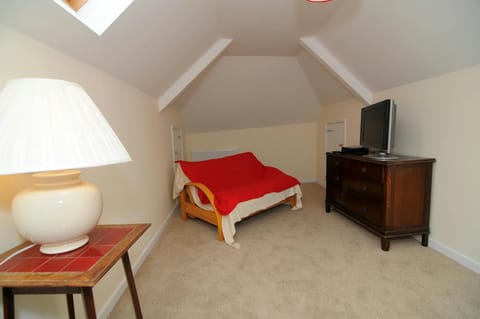 Second living room with sofa-bed, large drawer unit with TV, small table with lamp