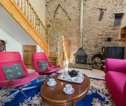 Sofa, two armchairs, coffee table, TV, bookshelves, view of kitchen, front door