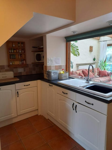 White base kitchen cupboards. Window looking into the conservatory