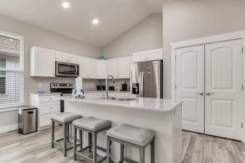 Full living room, with flat screen TV. Perfect for family vacations, or a couples getaway. Couch and loveseat. and living room attached to a kitchen with Island.