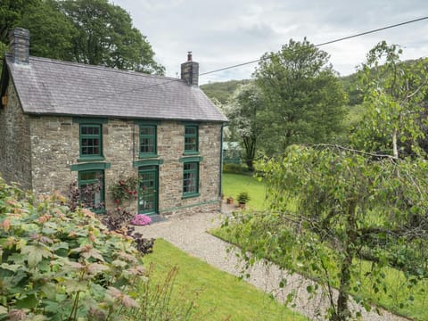 Front view of Rhyd y Brown House, gravel path, lawns, trees and shrubs