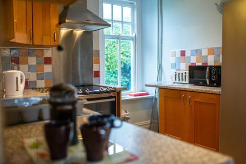 Kitchen, with wood wall and base units. Window looking onto the garden