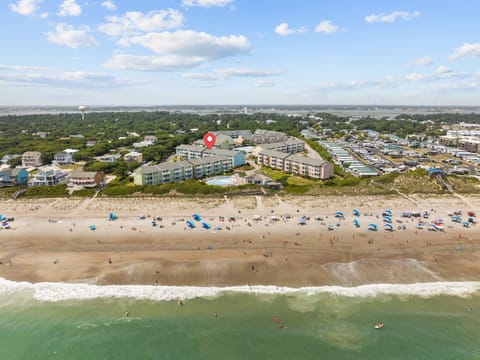 Aerial view of beachfront property complex with direct beach access and oceanfront location.