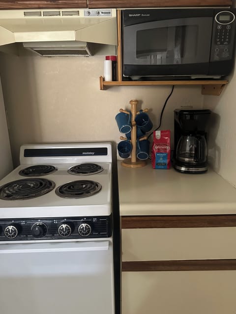 Stove, oven, microwave and coffee station.