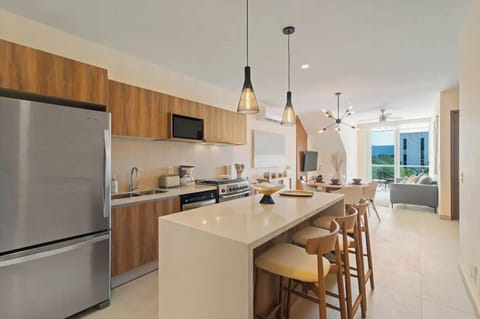 Seaside living: Penthouse with stocked kitchen, cozy living, elegant dining, private balcony.