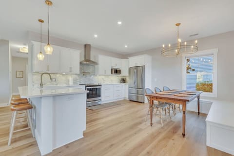 A farmhouse table with seating for 10 adjacent to the brand new kitchen with all new stainless appliances