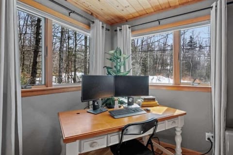 Our primary bedroom features a workstation with dual monitors and natural light for a productive stay