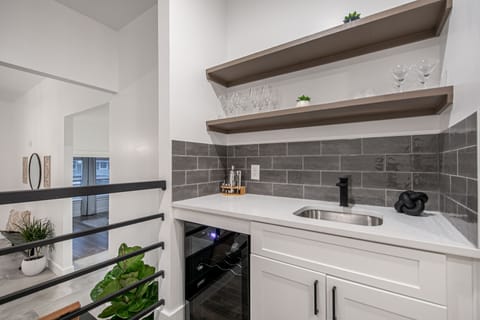 Bar area includes built in beverage fridge, bar tools, wine & martini glasses