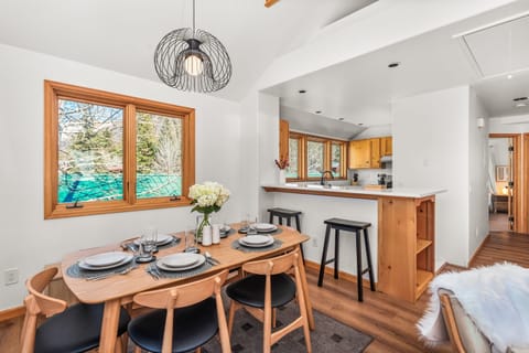 The open-concept living/dining room with large windows framing your riverside oasis