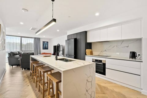 Sleek and modern, the fully-equipped kitchen centres around a marble island with ample bench and seating space.