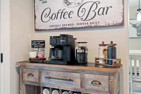 Dedicated coffee station with Keurig machine, ground coffee options, mugs, and morning essentials ready to go.
