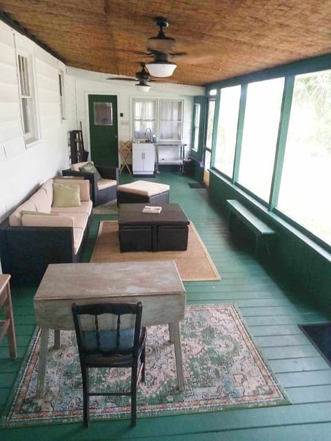 large screened porch with sink, ceiling fans, and electricity.grill is outside.