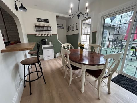 A farmhouse-style dining table, surrounded with four chairs, invites family and friends to gather for hearty meals and lively conversation. The counter height bar also offers additional seating through the peek-a-boo opening to the kitchen.