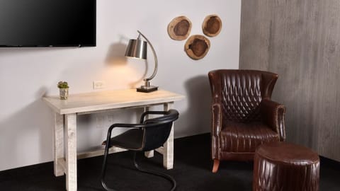 Focus easily at a quiet workspace beside a relaxing leather chair.