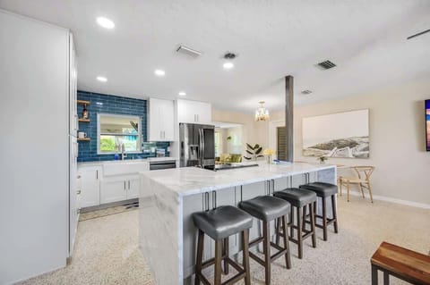 The kitchen is equipped with four counter-height stools, ideal for a quick meal before heading to the beach.