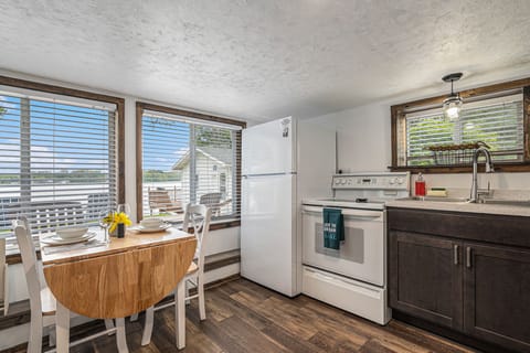 Kitchen, dining room table, electric stove and refrigerator