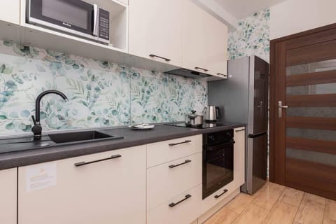 Fully equipped kitchen with upper and lower cabinetry, backsplash and dining area.