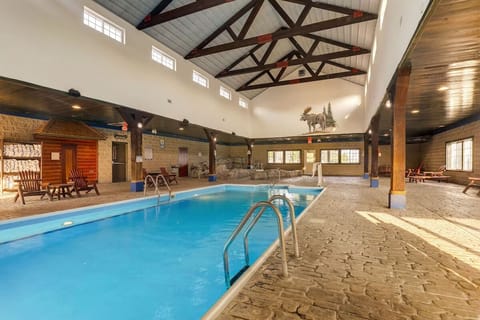 Dive into a spacious indoor pool beneath soaring beams.