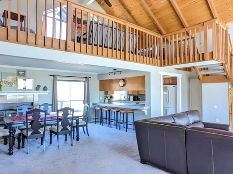 Living room, view of dining room, kitchen, upper loft, and large leather couch