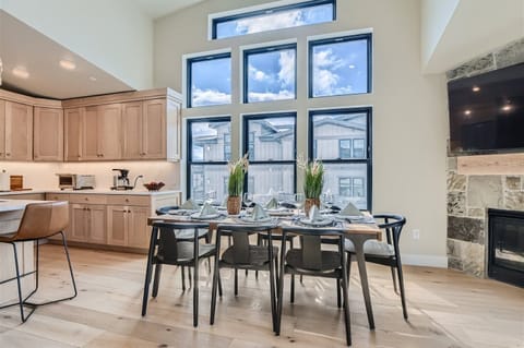Enjoy meals in this sun-drenched dining area featuring a stunning wall of windows and high-end modern seating. The open-concept design connects seamlessly to a gourmet kitchen, perfect for group entertaining.