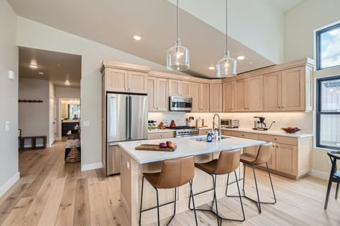 Prepare a gourmet meal in this chef-inspired kitchen featuring sleek quartz countertops and a spacious island with seating for three. High-end Viking appliances, under-cabinet lighting, and warm wood-toned cabinetry
