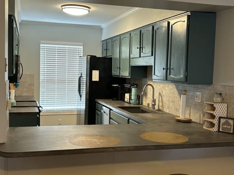 Stocked kitchen: coffee pot, Keurig, waffle iron, pots, pans & baking needs.