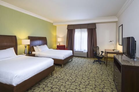 Unwind in a spacious double-queen room with soft daylight.