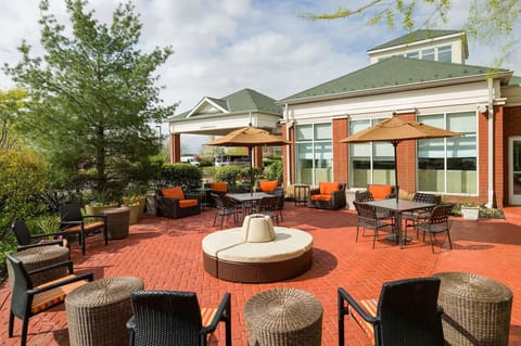 Unwind outdoors with cozy seating and sunny umbrella shade.