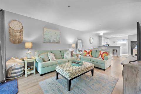Living room with flat screen tv and access to a screened in patio.