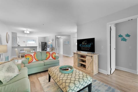 Living room with flat screen tv and access to a screened in patio.