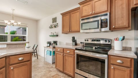 The well-equipped kitchen boasts modern appliances, beautiful wooden cabinetry, and a convenient breakfast bar for casual dining.