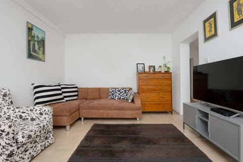 Cozy living room with wooden furniture, a comfortable sofa and a TV.