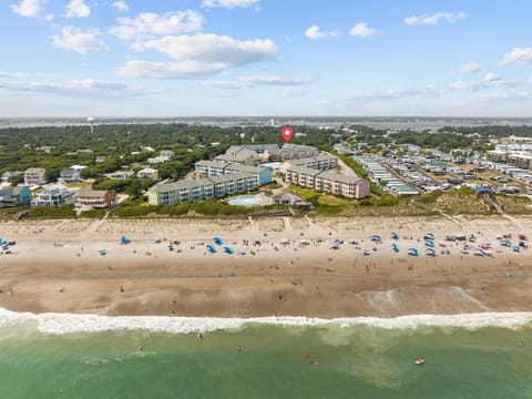 Beachfront resort complex with direct beach access and multiple buildings surrounded by coastal community.