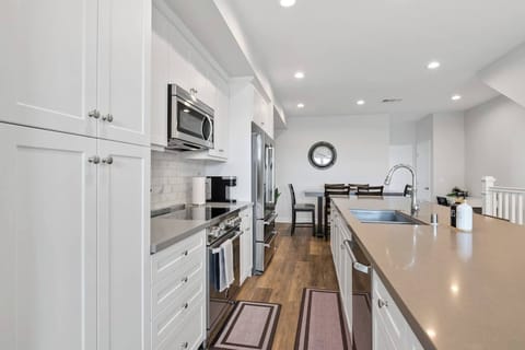 Open kitchen w/white cabinetry