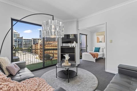 Inviting living room bathed in natural light, featuring a modern aesthetic, direct balcony access, and an adjoining flexible sleeping space.