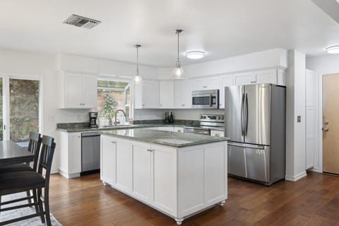 This bright gourmet kitchen features premium stainless steel appliances, a massive granite island, and seamless flow to the dining area.