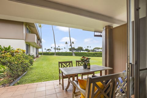 Enjoy al fresco dining on the private lanai with comfortable seating, vibrant cushions, and a lush green backdrop. Perfect for sipping morning coffee or evening cocktails.