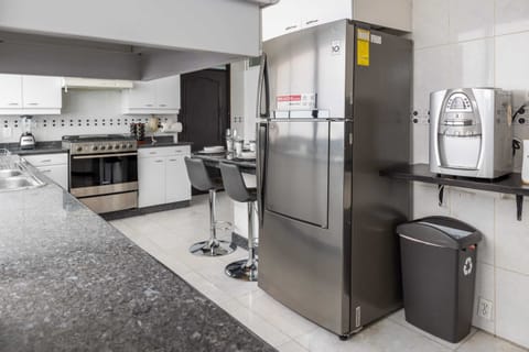 Modern kitchen with full-size refrigerator and all the essentials for cooking at home.