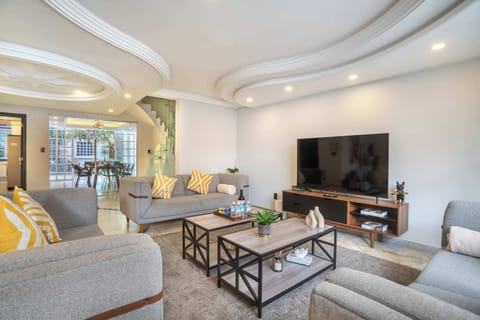 Spacious living room with plenty of natural light and a TV.