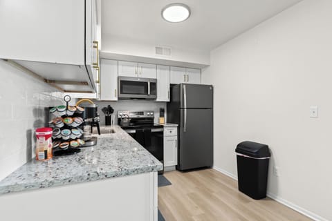 Modern galley-style kitchen with stainless steel appliances, quartz countertops, and ample cabinet space.