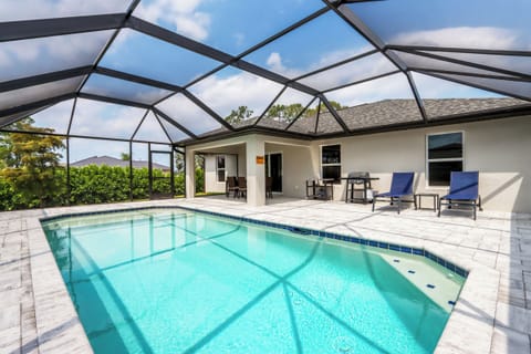 Heated pool surrounded by lush landscaping, creating a private backyard oasis perfect for relaxation