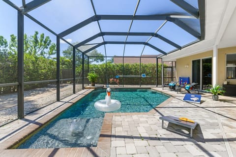 Outdoor screened-in patio with lots of comfortable seating, games and luxurious saltwater pool with Pebble Tec finish!