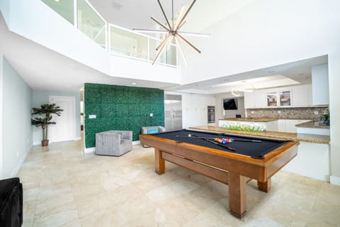 Stunning open-concept loft with a billiards table and dramatic lighting.