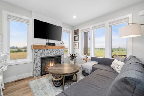 The main room features: electric fireplace, TV, l-shaped couch and coffee table.
