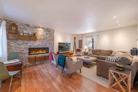 Spacious living room with comfy sectional couch, large TV, fireplace, games, and more.