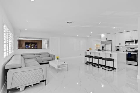 Spacious living room with sleek kitchen, cozy seating & modern decor.