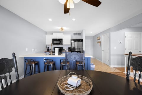 Modern kitchen with eat in bar and oven, dishwasher, microwave and refrigerator.