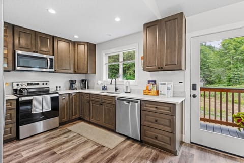 Cook like a pro in the upgraded kitchen—stainless steel appliances, large island, bar seating, forest views, and all the cookware you’ll need.