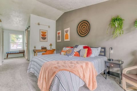 The primary bedroom has a king bed, large flat-screen TV, backyard access, desk space, and a private ensuite.
