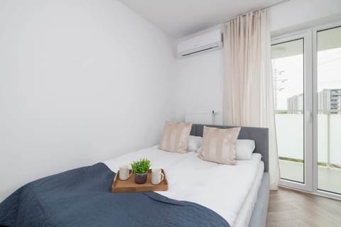 Modern studio with a comfortable double bed and access to the balcony.